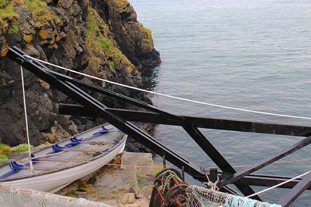 Undated handout photo issued by the National Trust of work being done to replace a crane to lift a fishing boat from the water onto the rocky Carrick-a-Rede island on Northern Ireland's North Coast