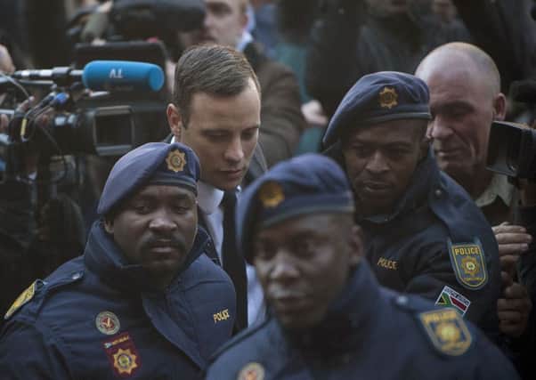 Oscar Pistorius, second from left, arrives at the High Court in Pretoria, South Africa Wednesday, July 6, 2016. A South African judge is expected to announce Pistorius' sentence for murdering girlfriend Reeva Steenkamp in his home on Valentine's Day 2013. (AP Photo/Shiraaz Mohamed)