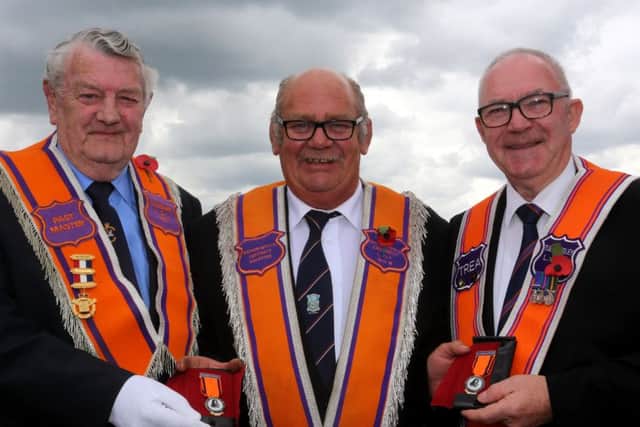 Tullygarley LOL 473 members Frank Gailbraith and Maurice Millar receive their 50 year jewels from Worship District Master David McConaghie, at the Ballymena Twelfth. INBT29-216AM
