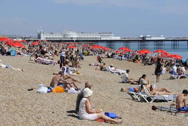 People enjoy the hot weather on Brighton beach on Monday, as a mini heatwave brings the hottest temperatures of the year. Photo: Lauren Hurley/PA Wire