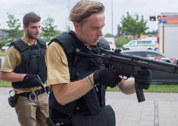 Armed policemen arrive at a shopping centre in which a shooting was reported in Munich, southern Germany, Friday, July 22, 2016. Situation after a shooting in the Olympia shopping centre in Munich is unclear.  (Matthias Balk/dpa via AP)