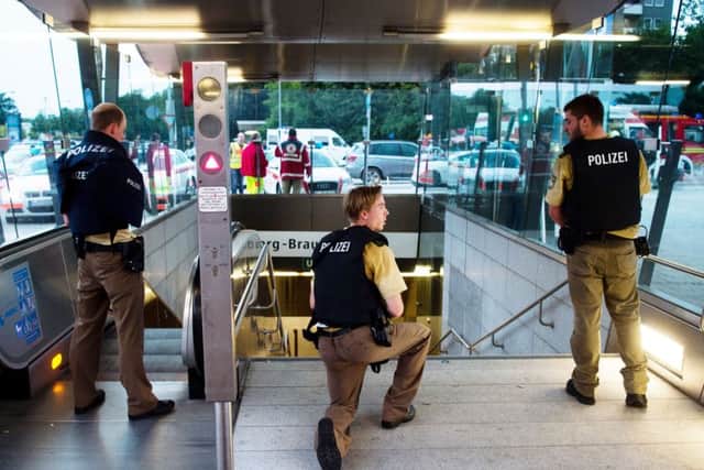 Policemen stand at the underground station Georg-Brauchle-Ring close to the Olympia shopping centre in which a shooting was reported in Munich, southern Germany, Friday July 22, 2016. According to media reports police expect several people being killed. (Lukas Schulze/dpa via AP)