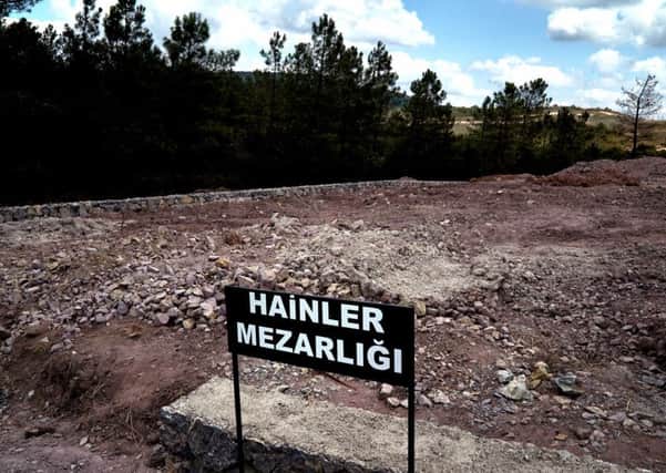 A sign reading in Turkish "Traitors' Cemetery" is seen in front of unmarked graves, built specifically to hold the bodies of coup plotters who died in the failed military coup of July 15, in eastern Istanbul. (AP Photo/Bram Janssen)