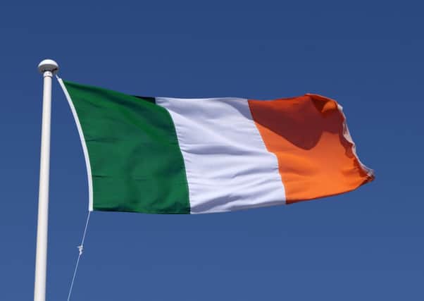 The Irish tricolour flag against a blue sky