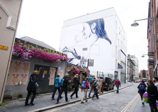 A five-storey mural depicting a married lesbian couple has been painted on a city centre building in Belfast