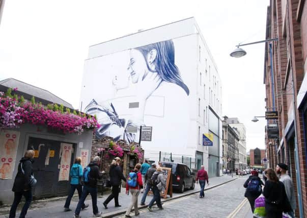 A five-storey mural depicting a married lesbian couple has been painted on a city centre building in Belfast
