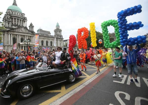 Participants pass city Hall as they take part in Belfast's annual Pride parade on Saturday
