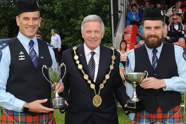 New Zealand Police Pipe Band lead drummer Angus Crowe and bass drummer Dale Stephens (band chairman) receiving the Grade 1 Best Drums trophies from the Chieftain of the Gathering Councillor Brian Bloomfield MBE, Mayor of Lisburn & Castlereagh City Council