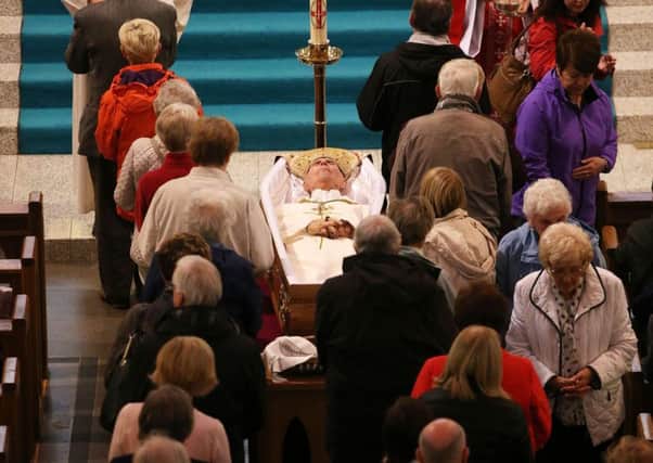 People pay their respects to the late Dr Edward Daly, Bishop of Derry, as his body lies in St Eugene's Cathedral in the city
