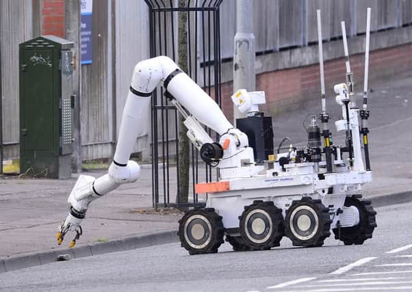 A bomb disposal robot inspects the suspect device