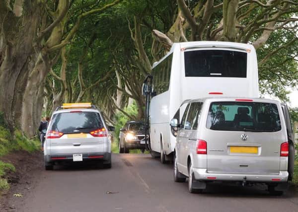 A coach and vehicle parked up on the side of the road, causing congestion for oncoming vehicles. Note the burnt residues from the white line mistake. Picture by Bob McCallion.