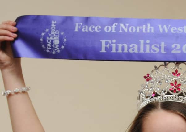 A child beauty pageant winner in England aged 10 holds victory banner