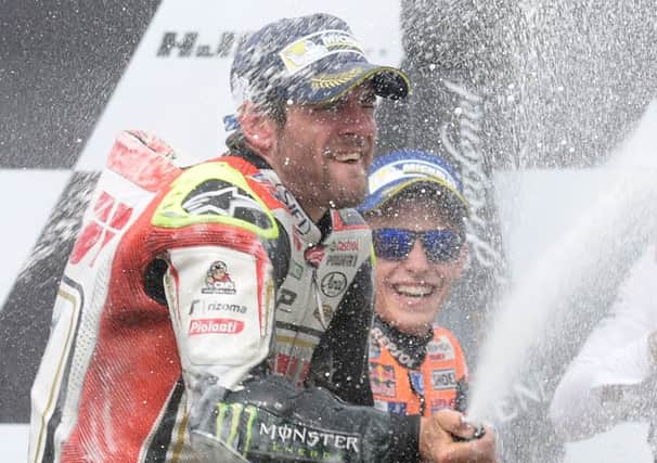 Cal Crutchlow celebrates on the podium after winning in the Czech Republic