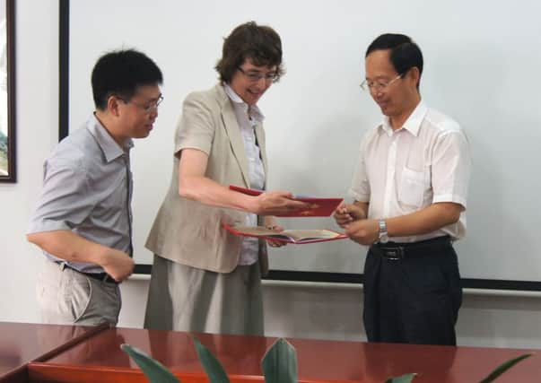 Dr Linda Farmer receiving certificates from Professor Dequan Zhang and Professor Changjiang Wang, to mark her appointment as Distinguished Professor and Distinguished International Supervisor at the Chinese Academy of Agricultural Sciences (CAAS)