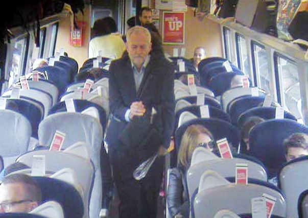 Labour Party leader Jeremy Corbyn, walking past several empty, unreserved seats in Coach F, after a video emerged last week which showed Mr Corbyn sitting on the floor, reading a newspaper