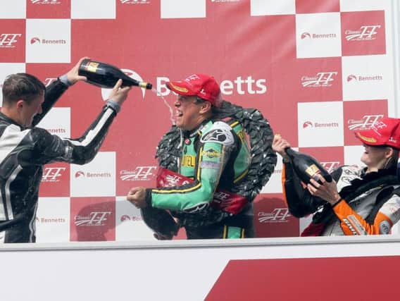 John McGuinness celebrates his victory in the Bennetts Senior Classic TT with runner-up Dean Harrison (left) and Maria Costello.