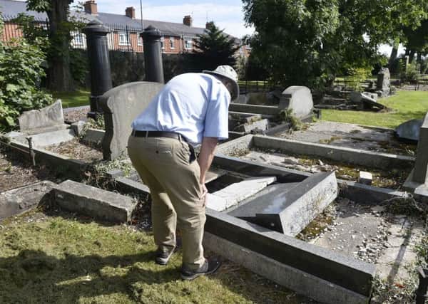 General views of the Jewish part of the City Cemetry in Belfast which has been vandalised.
Member of the public inspects his fathers grave after hearing of attack