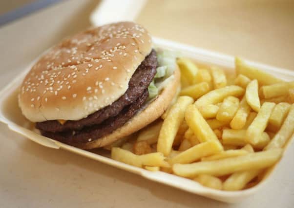 A half-pounder burger and chips in a takeaway carton. Eating meals late at night is putting millions of Britons at danger of suffering heart attacks. Photo: Philip Toscano/PA Wire