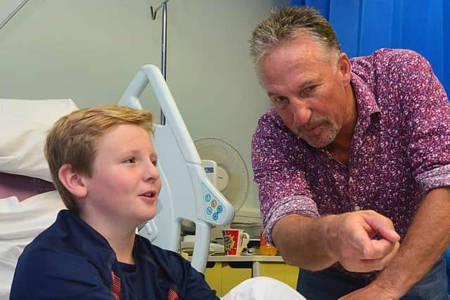 Sir Ian Botham with Euan Burrows from Newtownards during a visit to the Royal Belfast Hospital for Sick Children