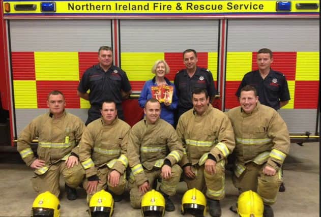 Kathleen Hughes pictured with firefighters from Keady Fire Station who responded to a chimney fire in her home. INNL 36-661-CON