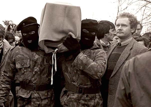 Sinn Fein's Martin McGuinness pictured with masked IRA men at the funeral of Brendan Burns in 1988. Pacemaker Belfast