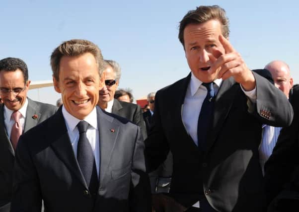 David Cameron (right) and then French President Nicolas Sarkozy arriving at Benghazi airport in Libya in September 2011