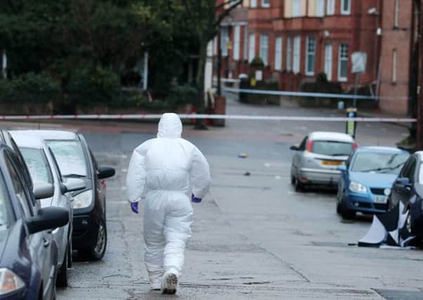 A forensic officer on the scene in the aftermath of the killing