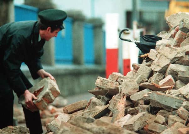 The IRA blew up the Enniskillen Remembrance Day service in 1987, killing 11 people and injuring many more. An RUC officer digs into the rubble with his bare hands in the aftermath, looking for survivors.