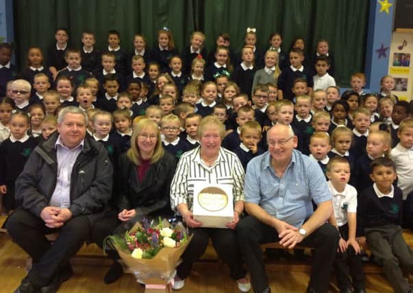 Dinner lady Sandra Kitchen (centre) celebrates 40 years at Blythefield Primary School in Belfast with husband Jackie (right), daughter Jaqueline Elder, son-in-law Alan Elder, and pupils