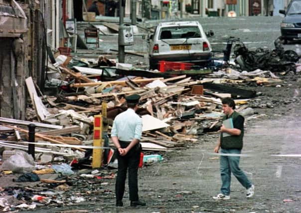 A Royal Ulster Constabulary police officer looking at the damage caused by the RIRA bomb in Omagh in 1998.
