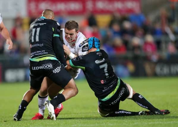 .Ulster's Darren Cave is tackled by the Ospreys Eli Walker and Justin Tipuric