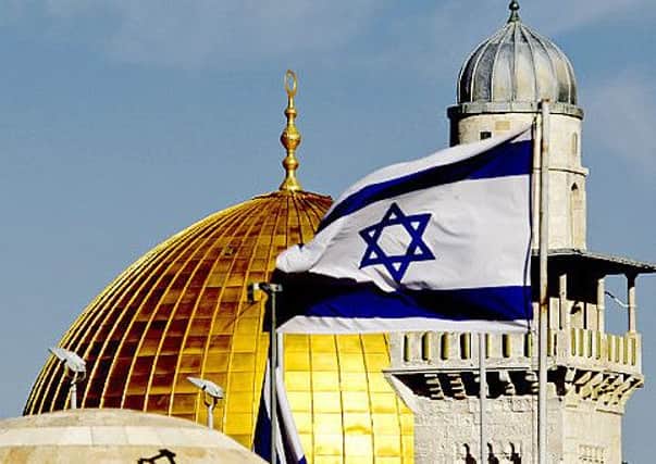 An Israeli flag is seen back-dropped by the Dome of the Rock Mosque in Jerusalem's Old City