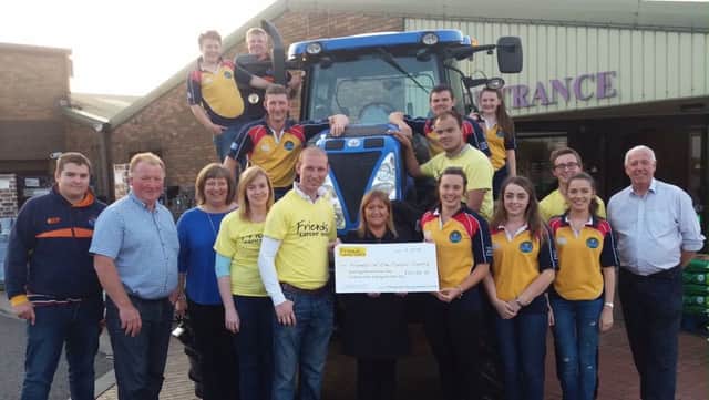 Moneyrea young farmers members and Andrew Gill and his family presenting the cheqe of Â£20,180 to friends of the cancer centre