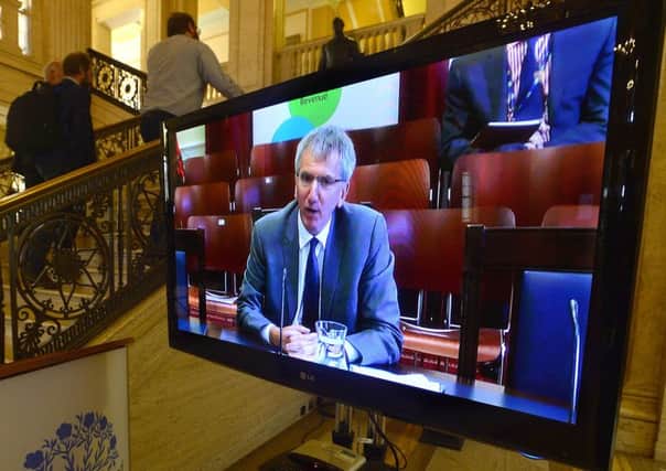 Mairtin O Muilleoir, who took over Stormont's finance ministry in May, is pictured on a TV screen in Stormont's Parliament Buildings.