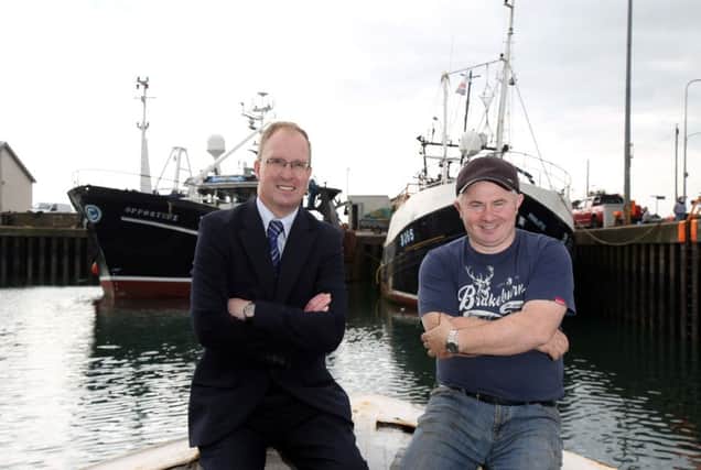 Keith Thompson, left, of Ulster Bank and Bill Coffey in Portavogie with The Opportune tied up behind them
