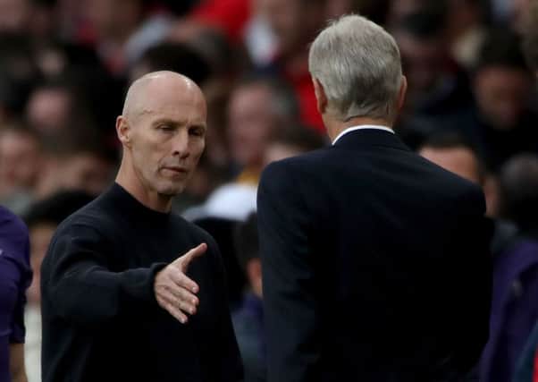 Swansea City manager Bob Bradley (left) shakes hands with Arsenal manager Arsene Wenger (right) after the final whistle during the Premier League match at the Emirates Stadium