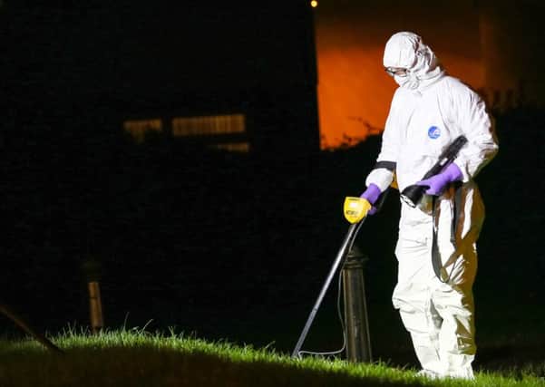 A forensic officer examines the scene of the paramilitary style attack in the Glenwood Drive area of West Belfast. (Photo by Kevin Scott / Presseye.)