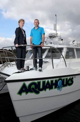 Richard Lafferty, owner of Portstewart-based Aquaholics pictured aboard the new boat in Ballycastle with Rhonda McClelland of Ulster Bank