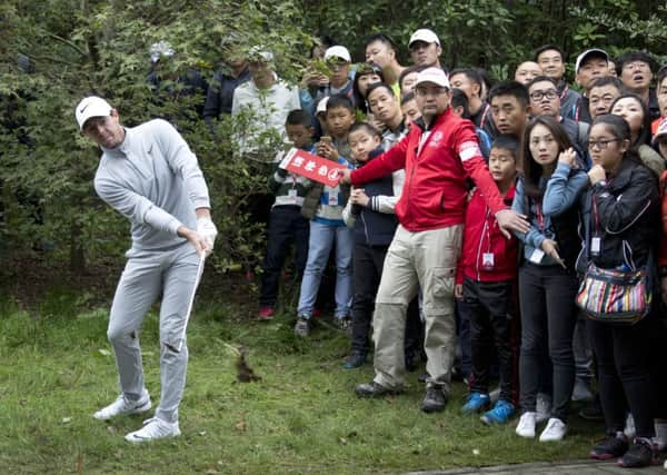 Rory McIlroy of Northern Ireland hits a shot from the bush during the 2016 WGC-HSBC Champions golf tournament at the Sheshan International Golf Club in Shanghai