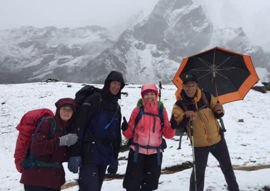 Mia McKeown, centre, with one of the Sherpas, right, and fellow climbers. The picture was taken just hours before she took altitude sickness. INPT44
