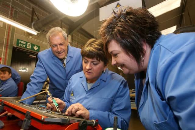 First Minister Arlene Foster takes on the task of soldering a circuit board under the watchful eye of Power Action employee Margaret Stewart and Councilllor Uel Mackin, Chairman of the council's Development Committee.
