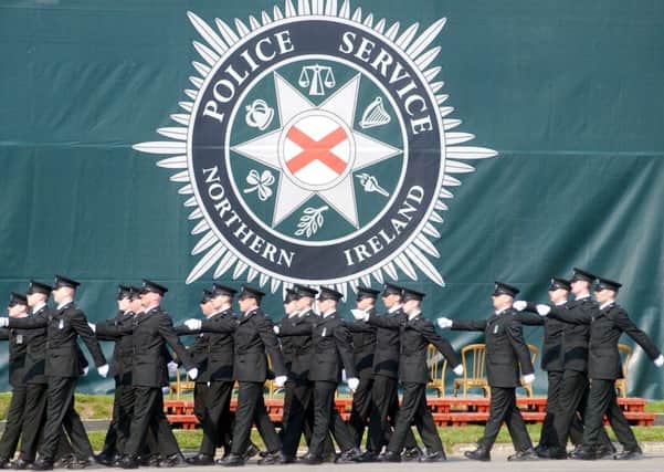 Police college graduates march past the PSNI flag during a graduation ceremony at Garnerville near Holywood