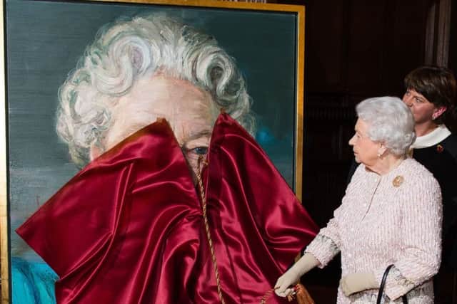Queen Elizabeth II unveils a portrait of herself by artist Colin Davidson. Photo credit should read: Jeff Spicer/PA Wire