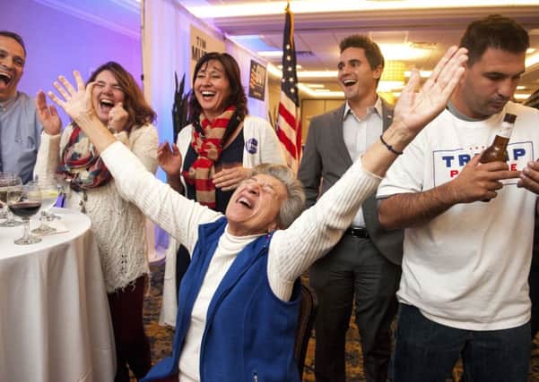 Georgia Touloumes, center, 86, of Venetia, Pa., shouts in joy surrounded by her family as more states are announced for Republican presidential candidate Donald Trump on TV at and election night party in Pittsburgh on Tuesday, Nov. 8, 2016. (Stephanie Strasburg/Pittsburgh Post-Gazette via AP)