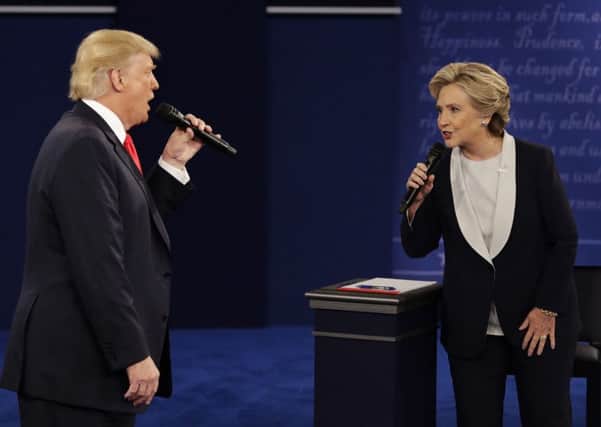 Donald Trump and Hillary Clinton speak during the second presidential debate at Washington University in St. Louis, Sunday, Oct. 9, 2016. (AP Photo/John Locher)