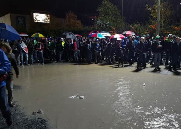 NI fans try to navigate huge puddles as they leave Windsor Park after tonights game.
