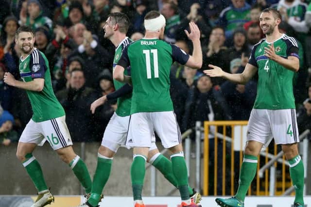 Northern Ireland's Gareth McAuley (right) celebrates with team mates after scoring his sides second goal of the game during the 2018 FIFA World Cup qualifying, Group C match at Windsor Park, Belfast. PRESS ASSOCIATION Photo. Picture date: Friday November 11, 2016. See PA story SOCCER N Ireland. Photo credit should read: Brian Lawless/PA Wire. RESTRICTIONS: Editorial use only, No commercial use without prior permission