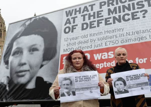 Christine Quinn (left) and Roberta Quinn, the daughters of Christopher Quinn,  in front of a poster in Westminster, London