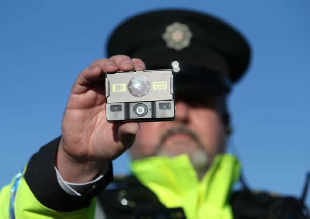 Inspector Alan Swan shows off one of the 400 tiny video recorders that will be deployed in Belfast