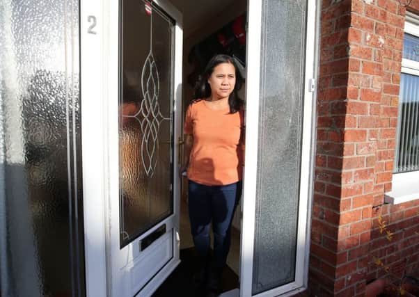 Cleo Enriquez at her Ballysillan home that had window in its door shattered in the latest attack